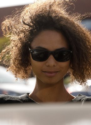 Молодая негритянка в коротких шортах гуляет на улице